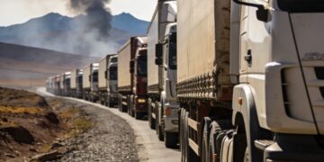 Vista de camiones de carga de alto tonelaje detenidos pacientemente sobre una autopista desértica en el altiplano de Bolivia