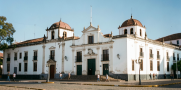 Detalle de una calculadora clásica y documentos presupuestarios en una oficina gubernamental.